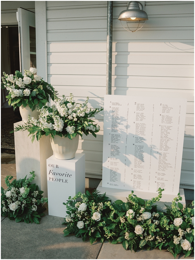 fine art wedding photo of a creative guest seating chart featuring potted plants on multi-tiered pedestals